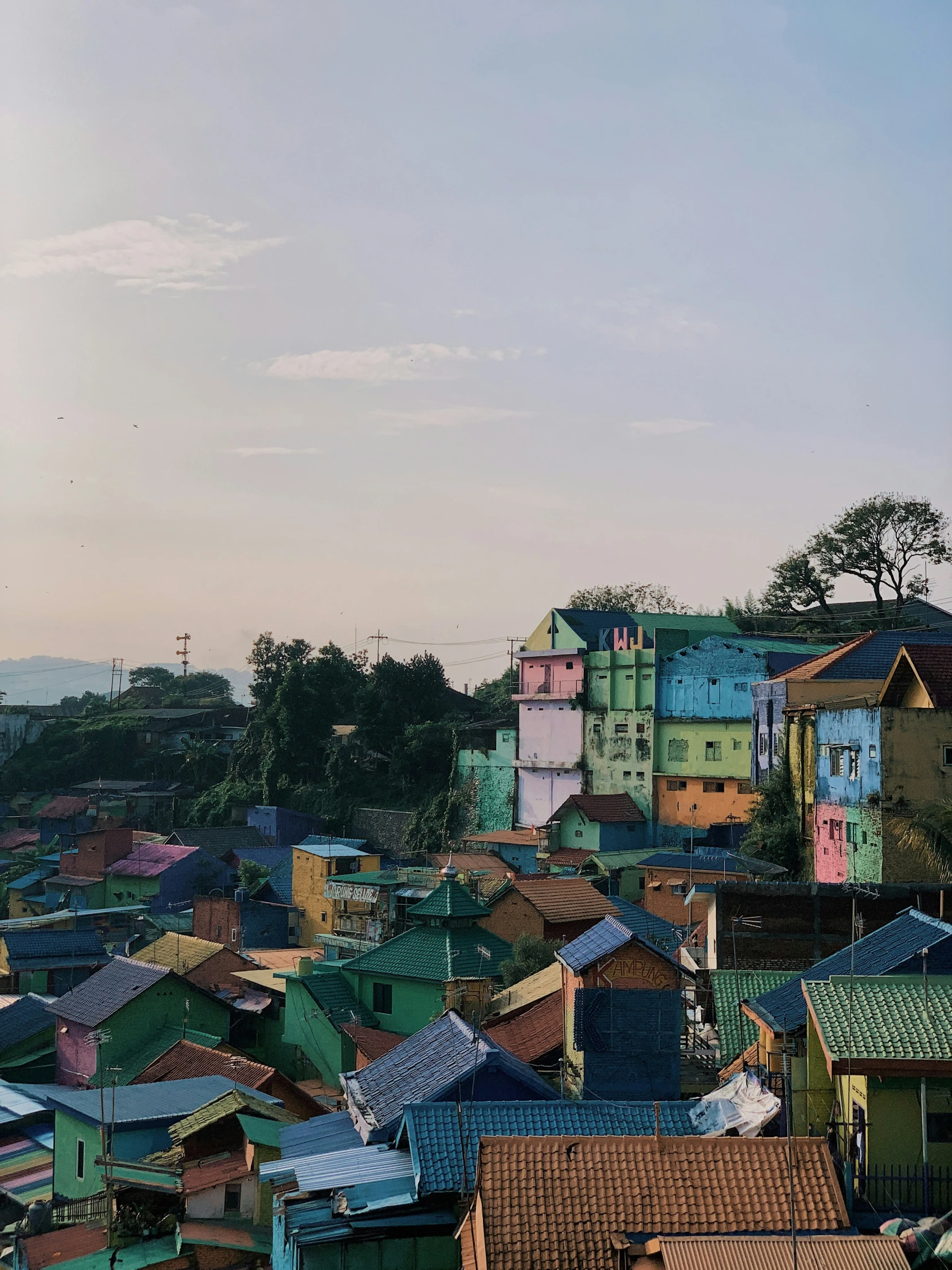 a small city has many colorful roofs and a tall clock tower