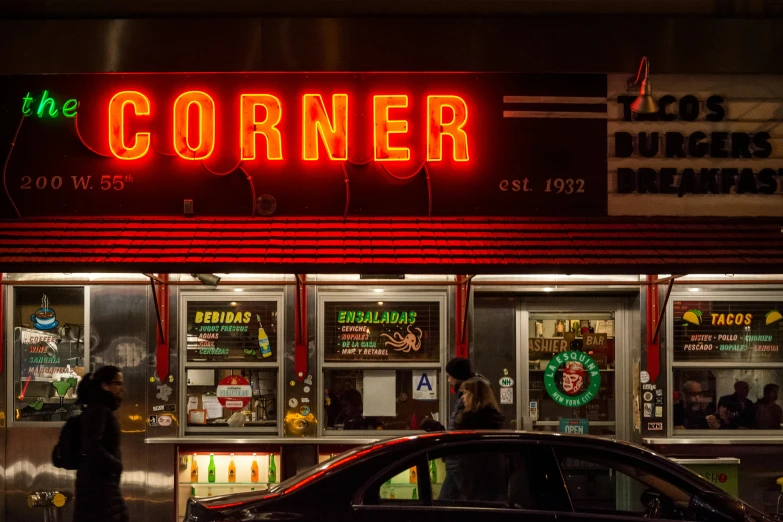 the corner has neon signs lit up on the front