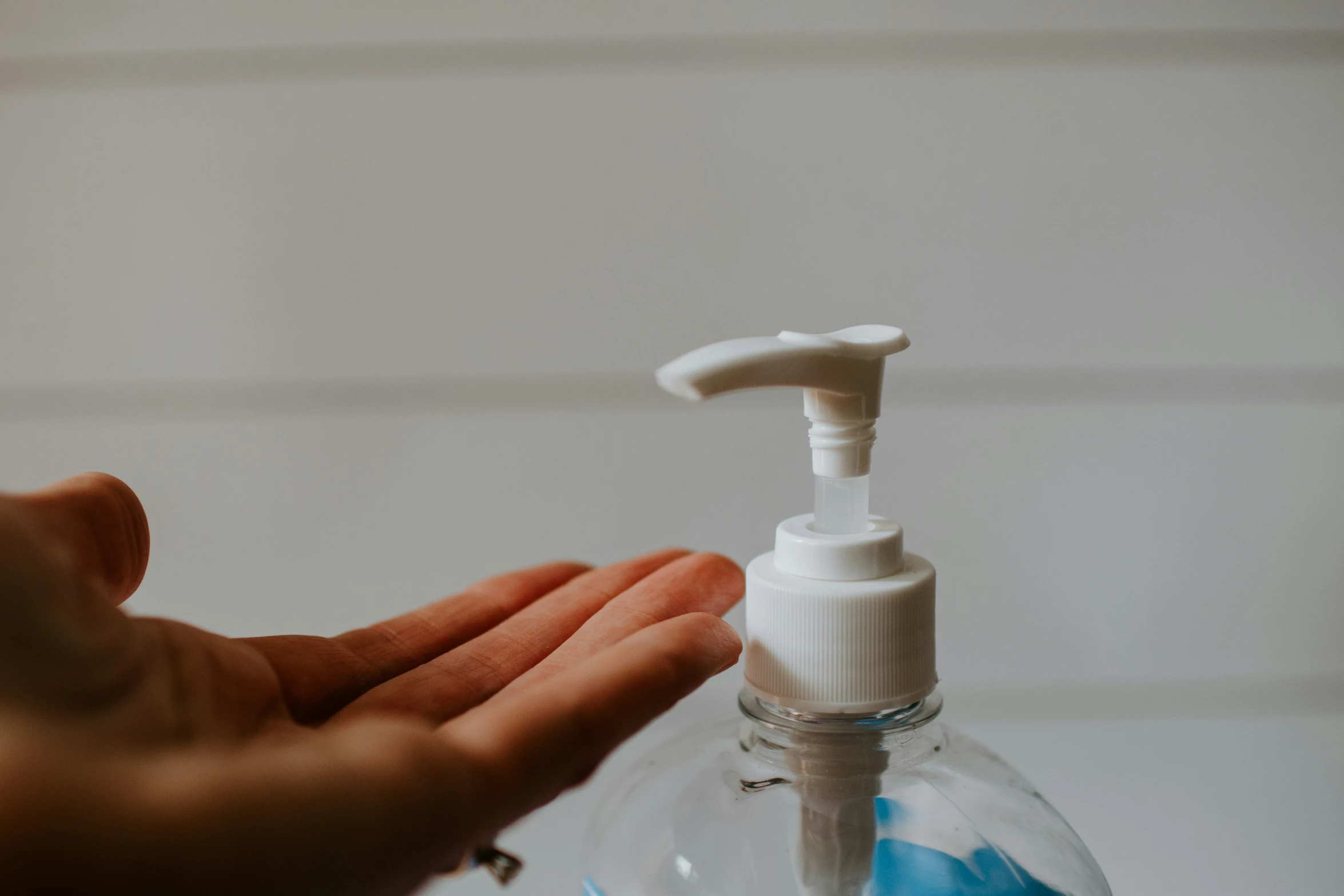 someone is holding an empty liquid bottle with a spray of soap