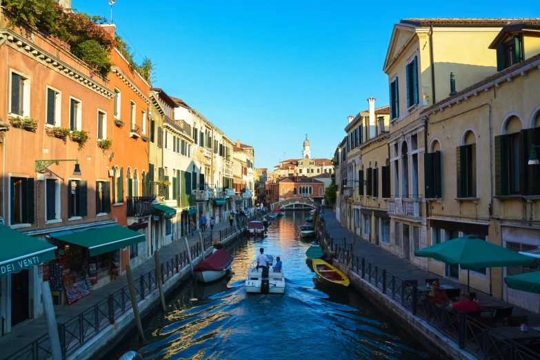 two boats ride down a narrow canal