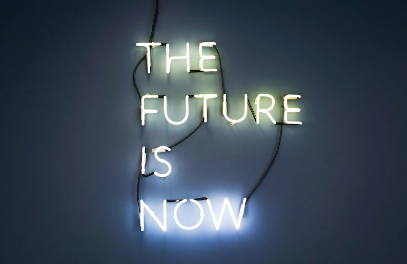 a neon sign that reads the future is now