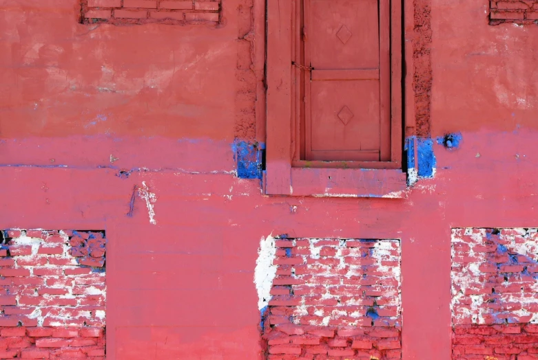 a red brick wall with blue shutters and windows