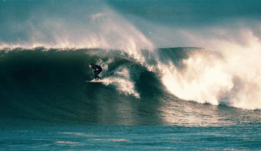 a man riding a wave on top of a surfboard