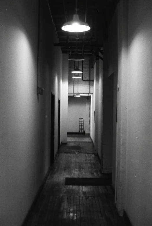 an empty building hallway with stairs and lights