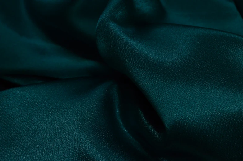 closeup of green silk fabric on a white surface