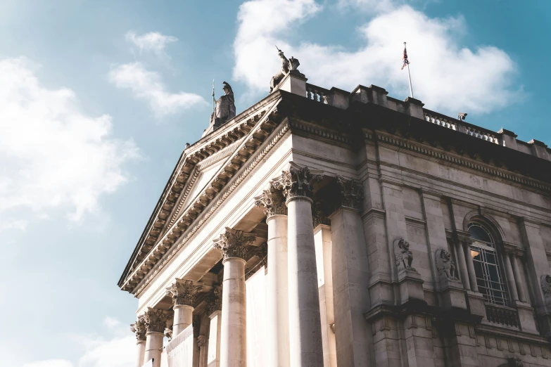 an architectural building with columns and sculptures on top