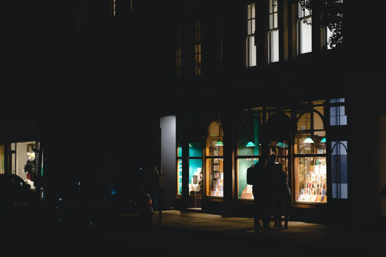 two people are in the dark at night by a store