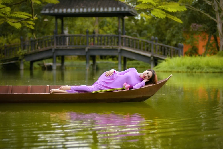 a woman in a purple outfit laying on a boat