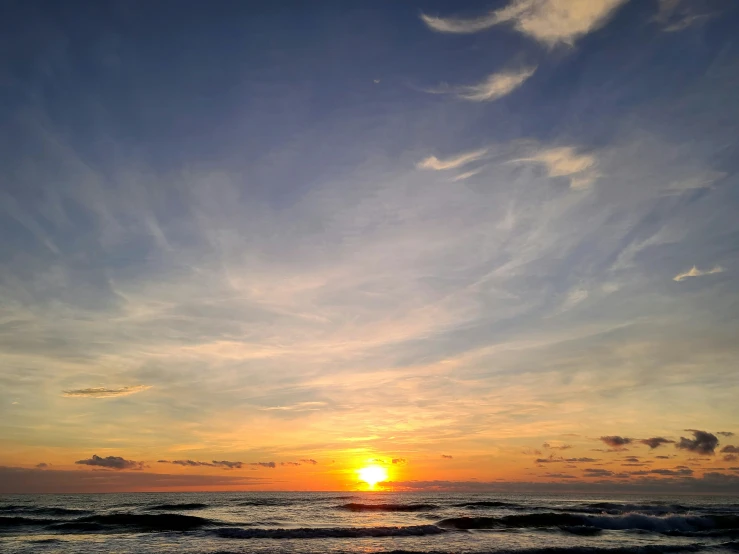 the sun is setting on the ocean beach