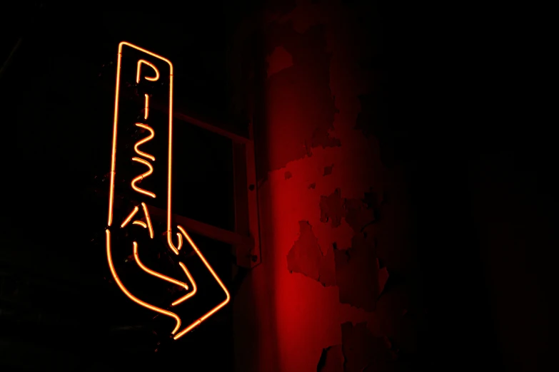 a neon sign is lit up red on the wall