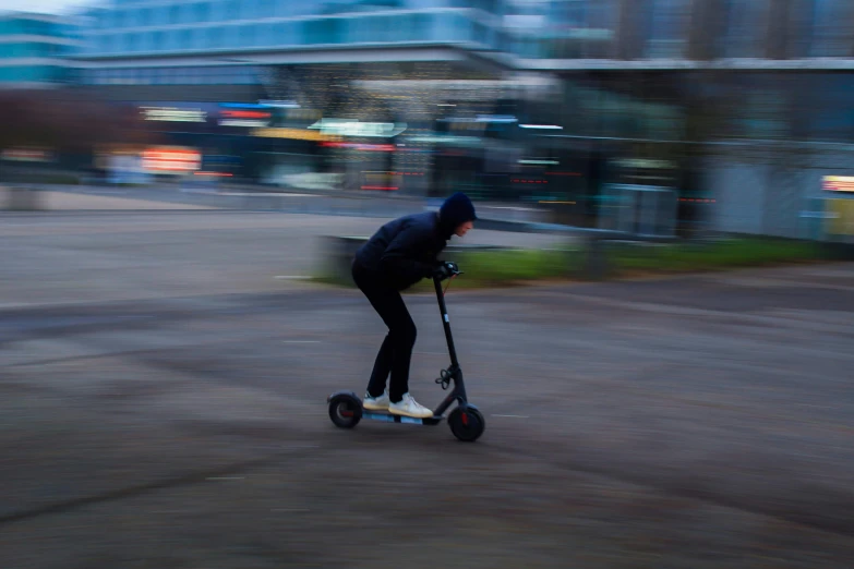 man on a scooter with no helmet riding along