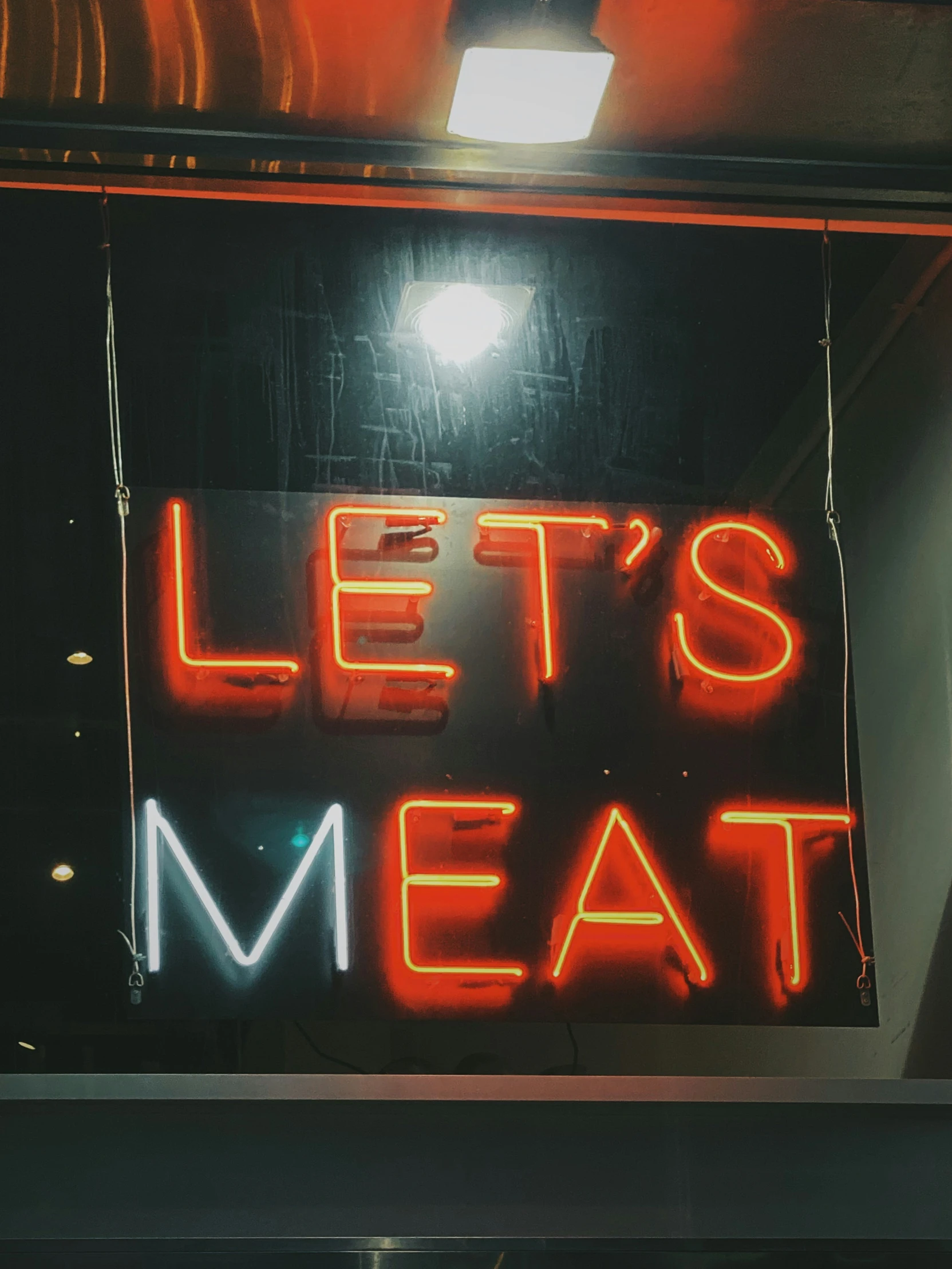 a neon sign is on display inside of a restaurant