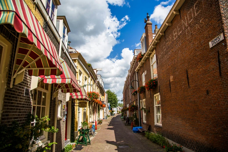 street scene of an empty street with buildings and a cloudy blue sky