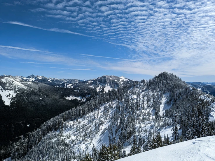 snow covered mountain tops in the distance and some clouds in the sky