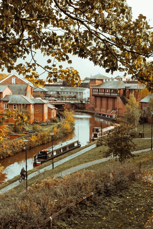 a river running between two old buildings and some trees