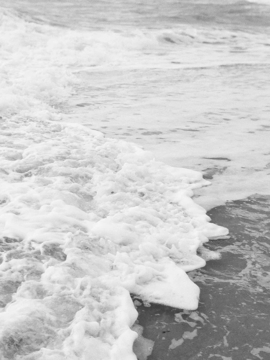 black and white image of waves and water at the beach