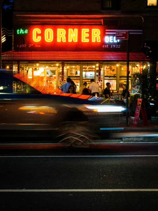 the corner restaurant has neon signs that are lit up