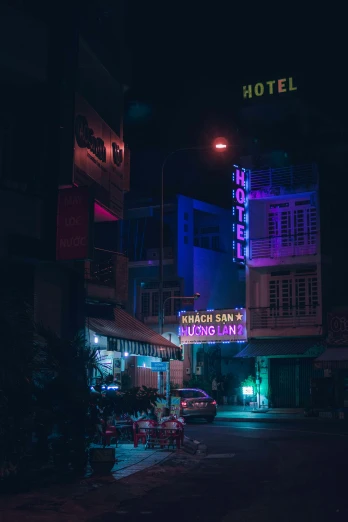a dark lit street in the middle of a building with colorful lighting on top
