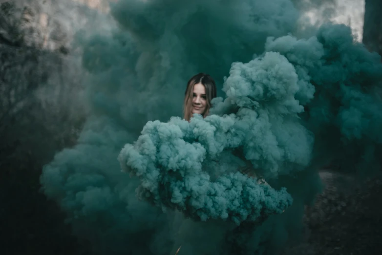 woman in black is holding out blue smoke