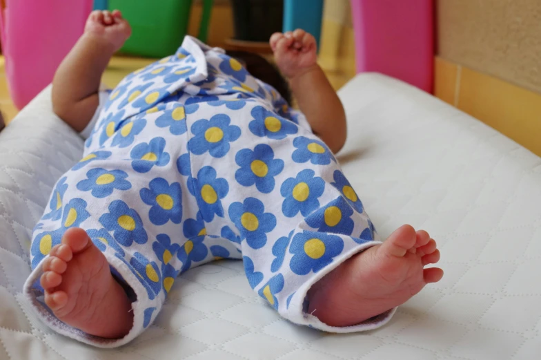 a baby is lying on a white bed