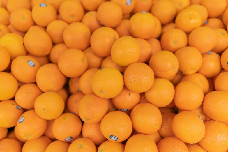 large pile of oranges piled up in a fruit stand