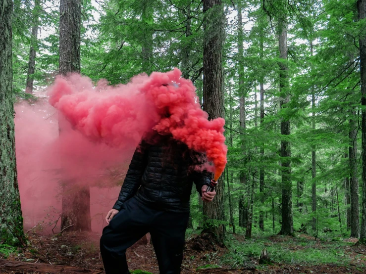 a man is walking and colored by pink smoke