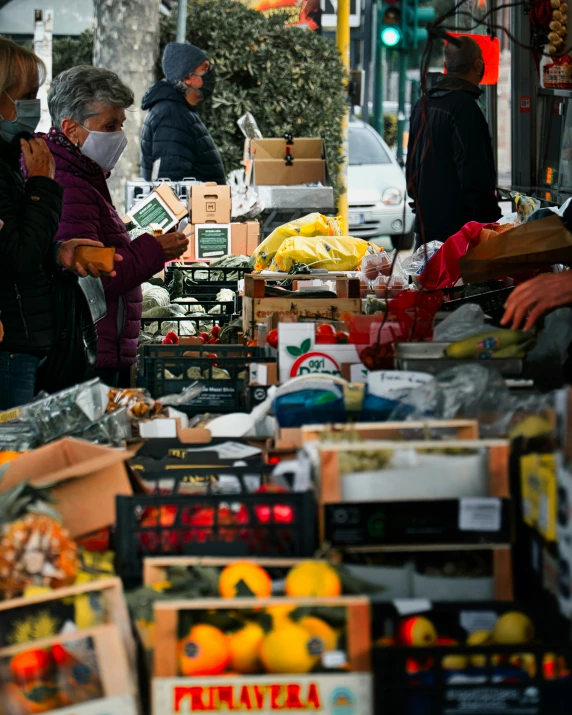 there are several people outside at a street vendor