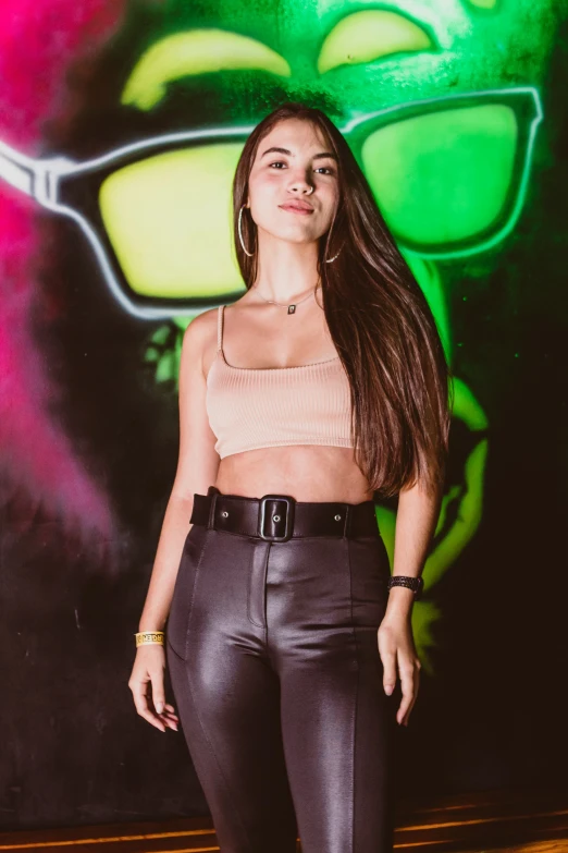 a beautiful young lady posing in front of a wall