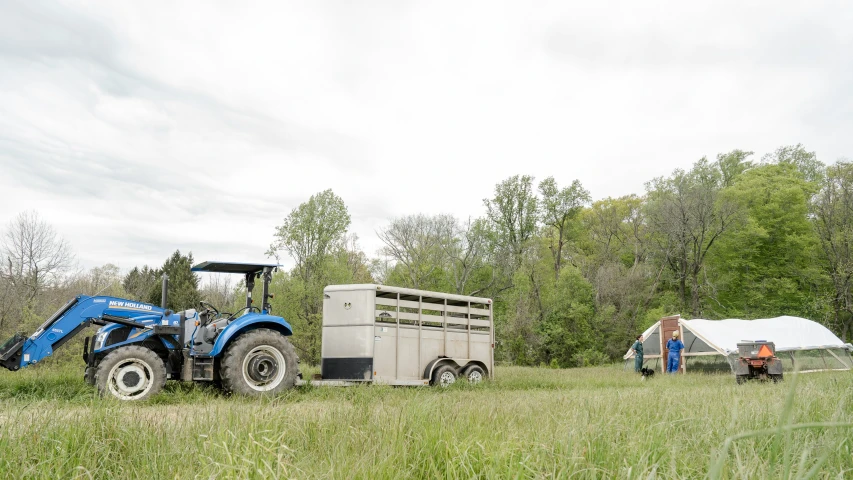 tractor on an unicycle on the grass next to the farm