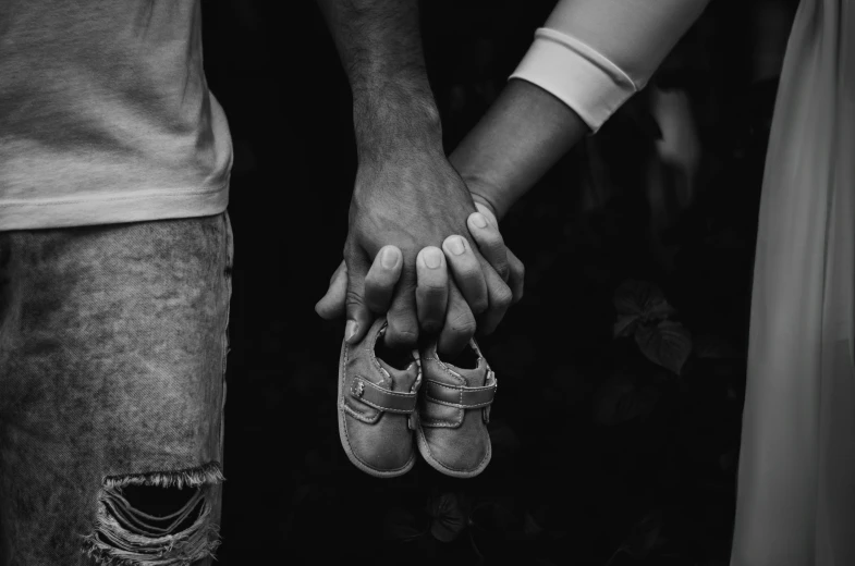 a black and white po shows three people holding their hands in black