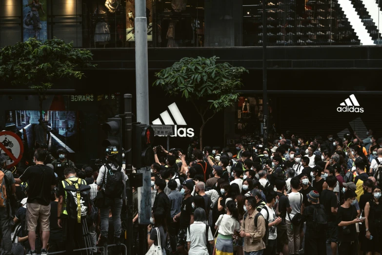 crowd of people standing in street next to building