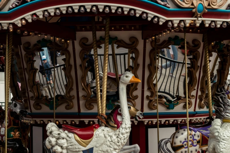 a merry go round with several horses and a goose