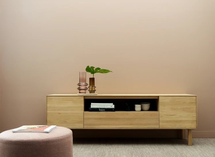 an empty chair and wooden cabinet in front of a wall