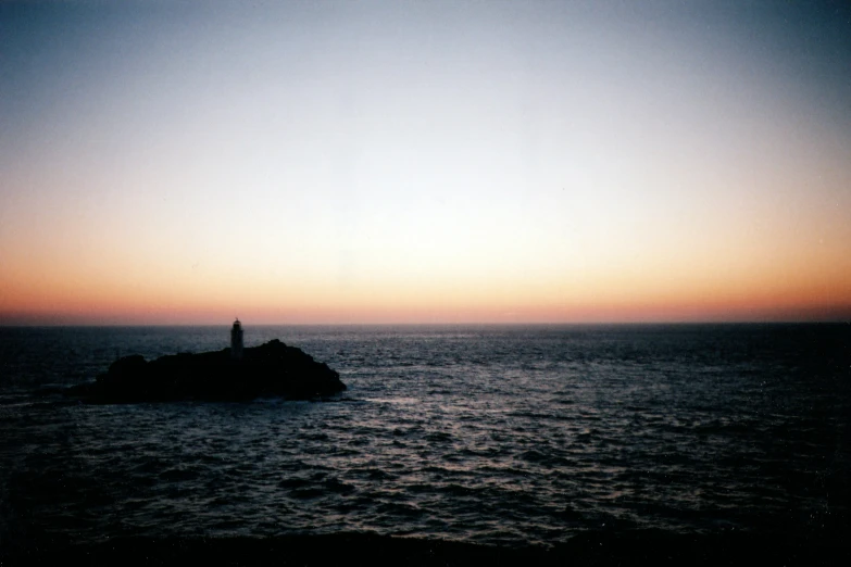 a boat floating through a body of water at sunset