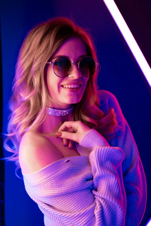 a beautiful woman in sunglasses and pink sweater