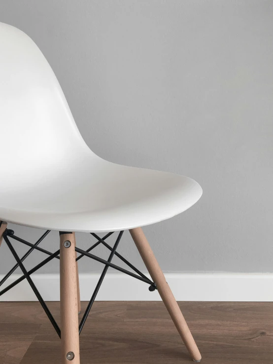 a white plastic chair with wooden legs
