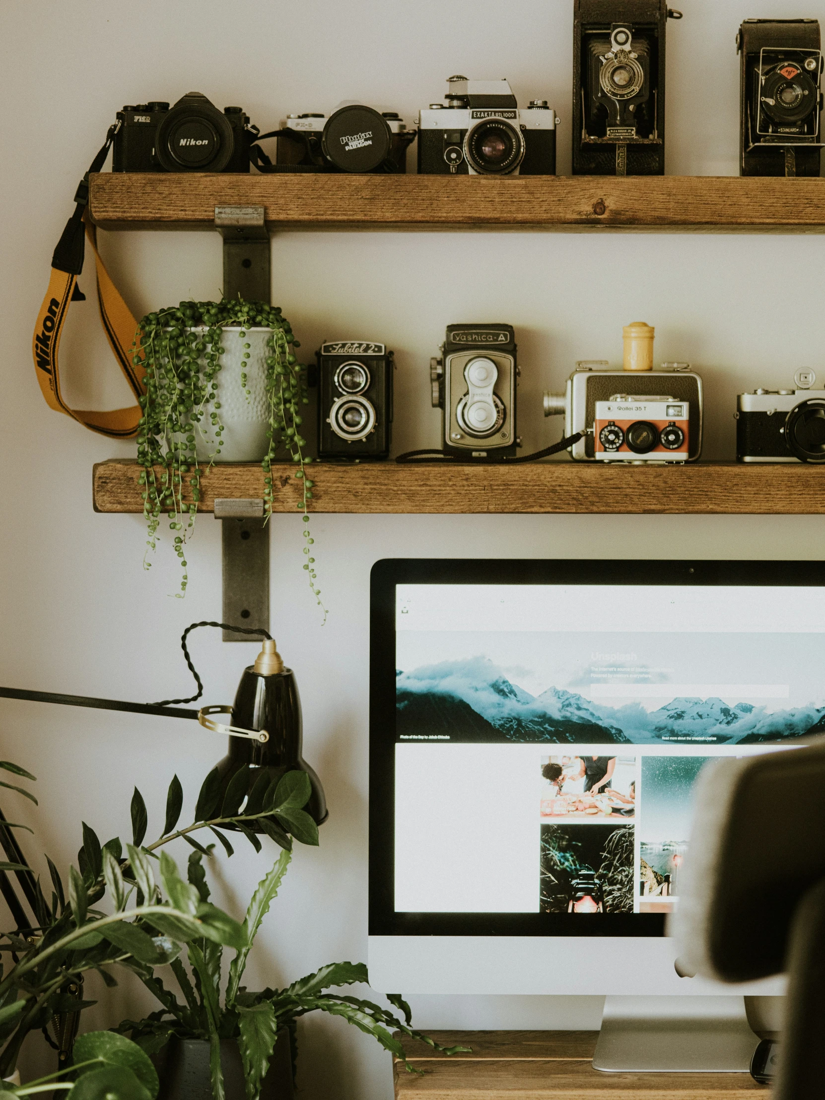 a monitor and some camera are on a desk