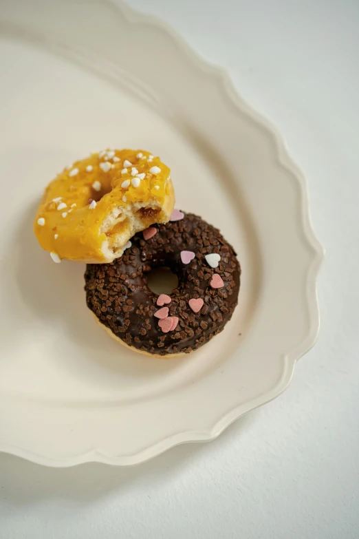 two donuts on a plate decorated with hearts