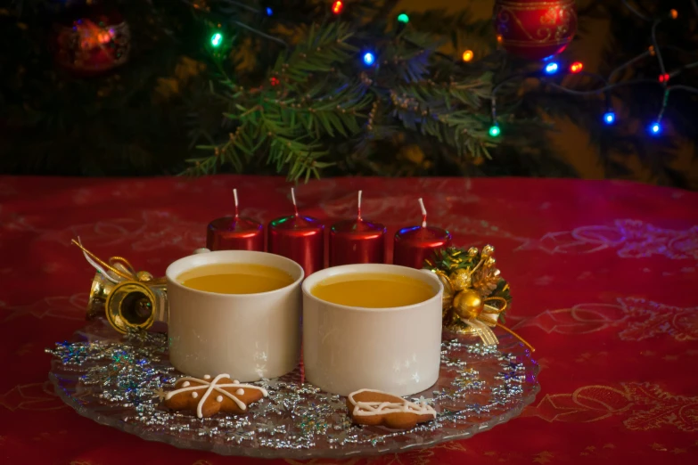 two coffee mugs filled with tea are on a plate