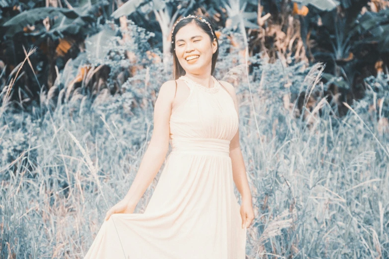 a woman standing in a field with tall grass