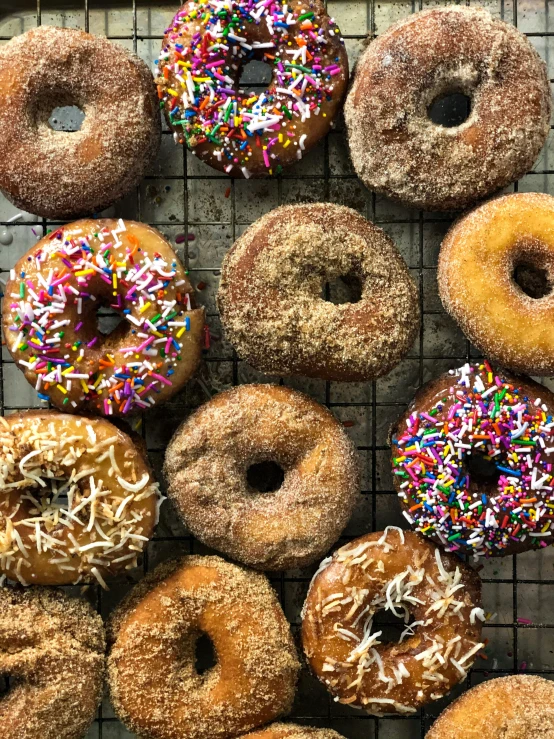 a close up of many different flavored doughnuts