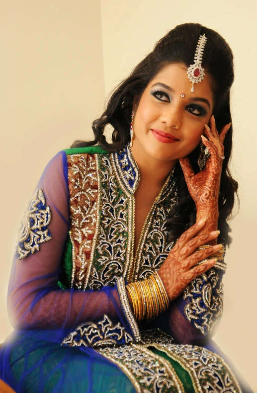 a woman in traditional indian bridal wear poses for a portrait