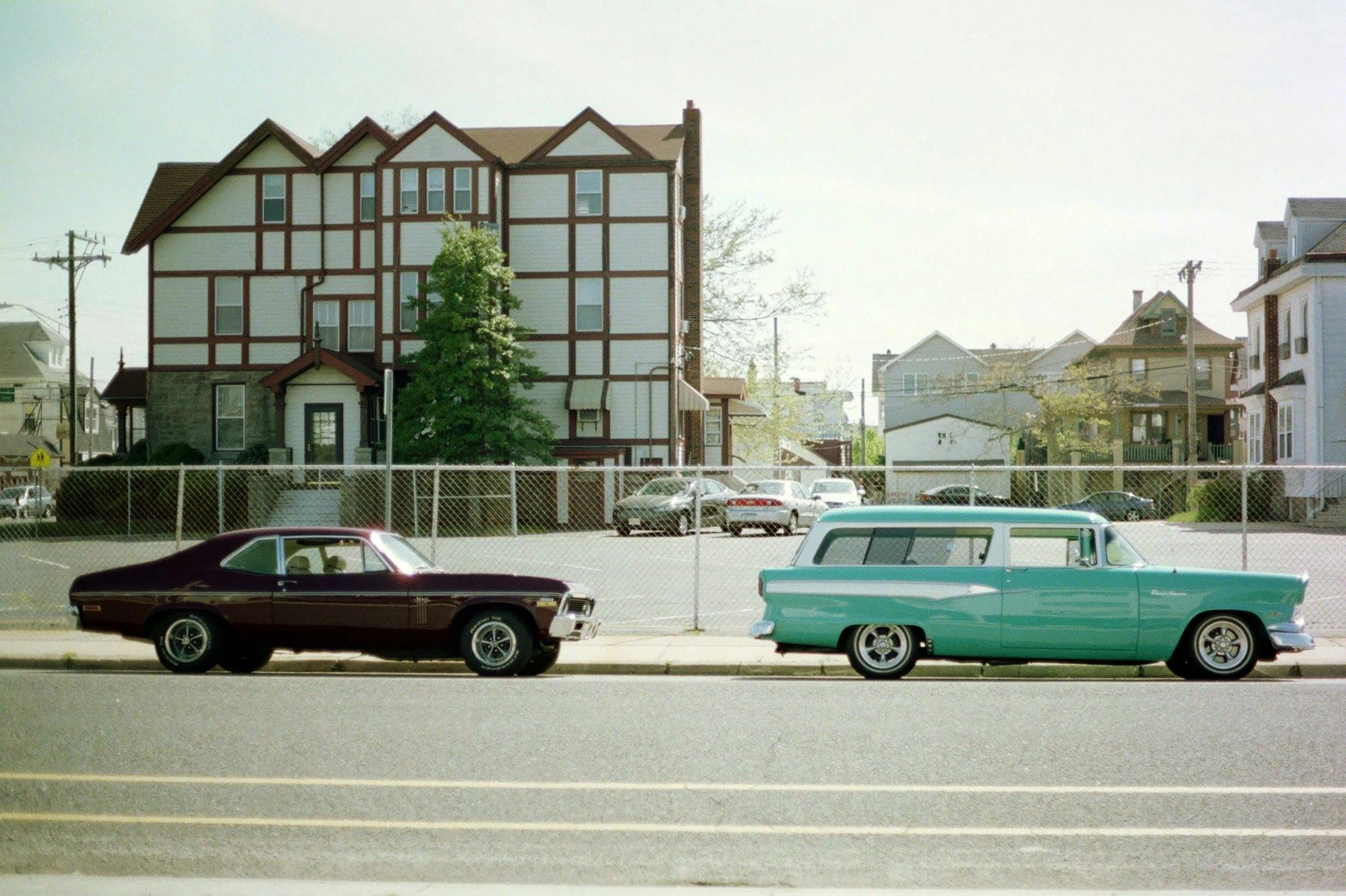 two old cars are parked next to a sidewalk