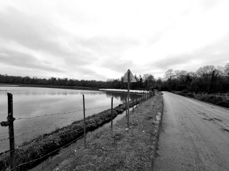 a black and white image of water with the sky reflecting off of it