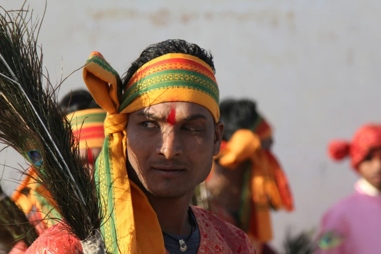 an indian man with his head scarf wrapped around him and dressed in colorful attire