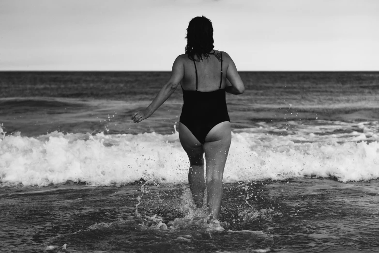 a woman in a one piece swimsuit is splashing around the water