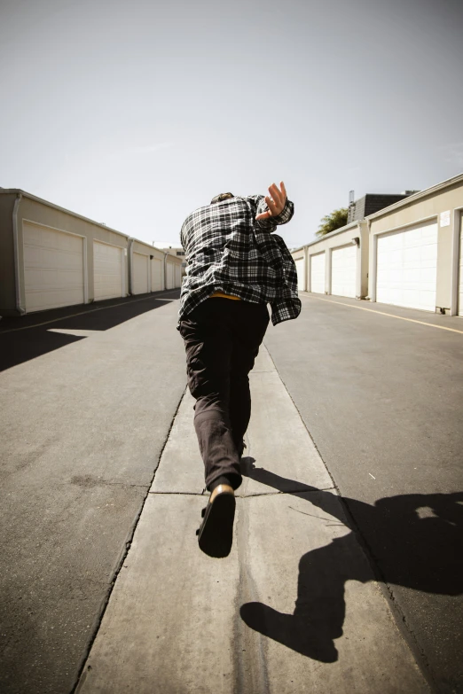 a man on a skateboard rides down the sidewalk