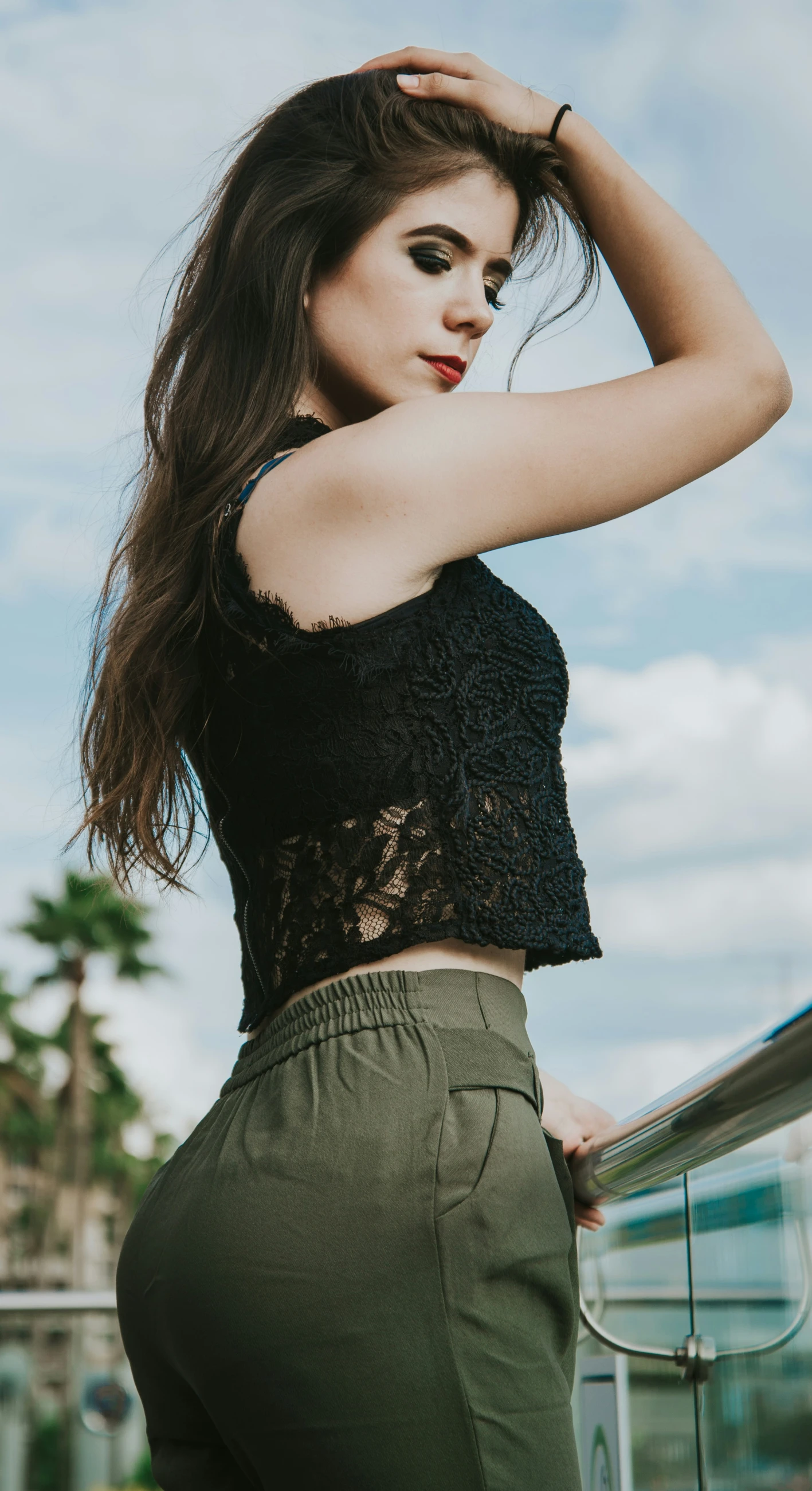 a young woman posing for the camera while leaning against a wall