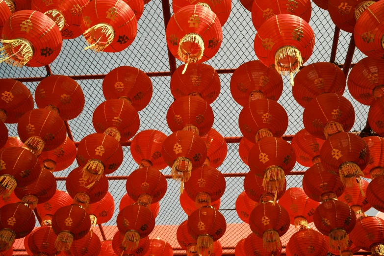 a fence with lots of red decorations hanging from it