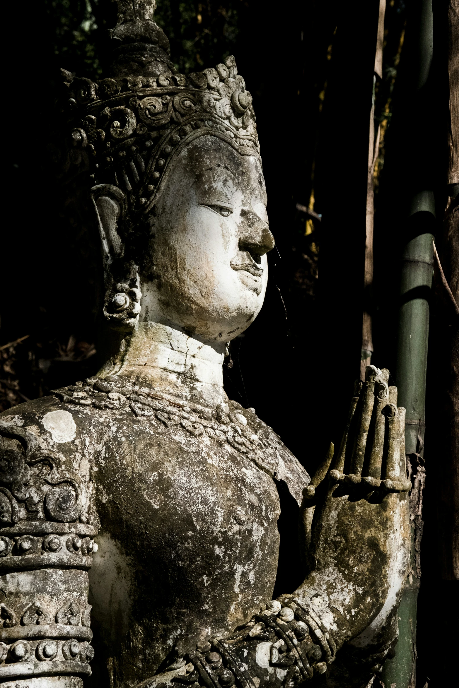 a statue of an asian buddha praying with his hand together